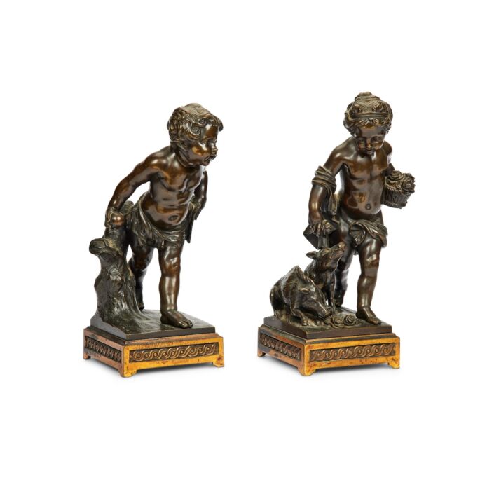A pair of mid 19th century French patinated bronze figures of a girl and boy putti